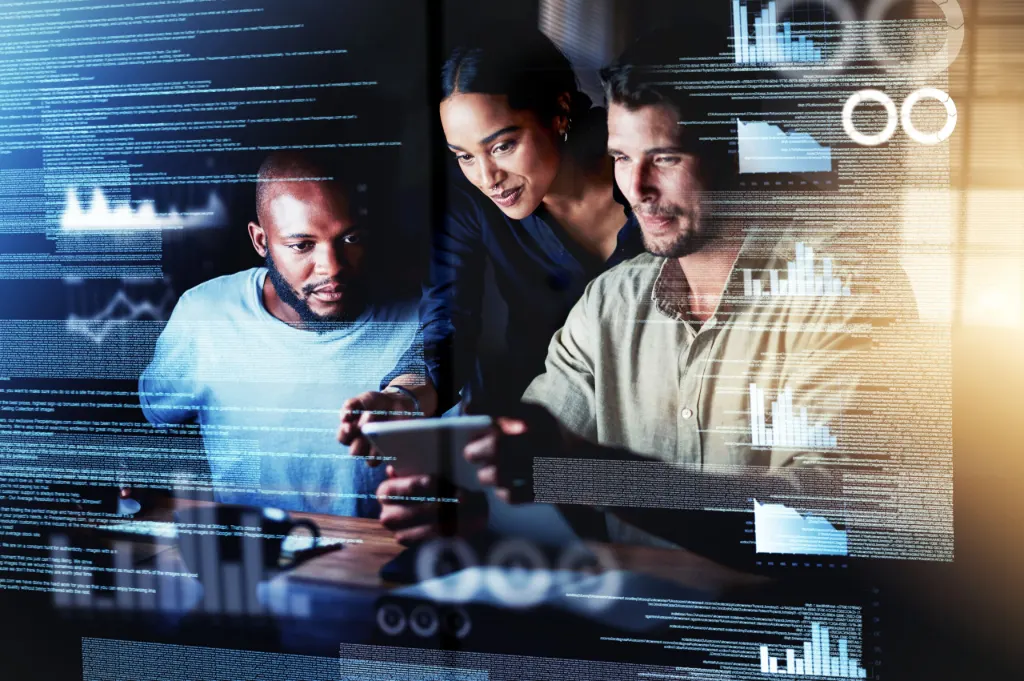 Deux hommes et une femme d’origines diverses collaborent autour de données et de code sur des écrans numériques, illustrant la diversité dans les métiers IT
