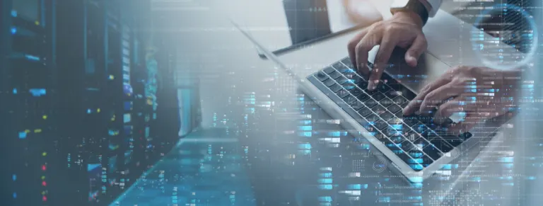 Mains utilisant un ordinateur portable devant des serveurs informatiques illustrant les échanges autour du processus de recrutement IT